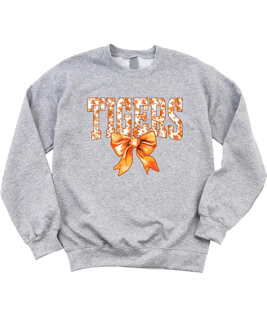 Close-up view of Tigers sweatshirt showing orange bow detail and bold team lettering on black fabric