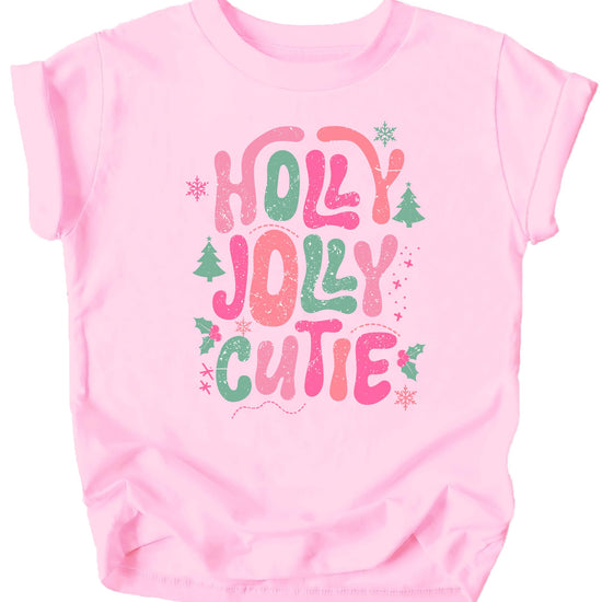 Close-up of Holly Jolly Cutie holiday graphic print on pink youth tee showing candy cane lettering detail