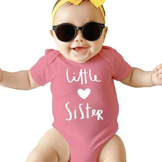 Baby girl wearing Little Sister heart bodysuit, ideal for sibling announcement photos