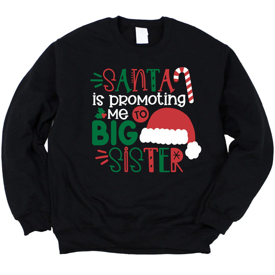Close-up of vibrant Santa 'Promoted to Big Sister' graphic print on a cozy youth girls sweatshirt
