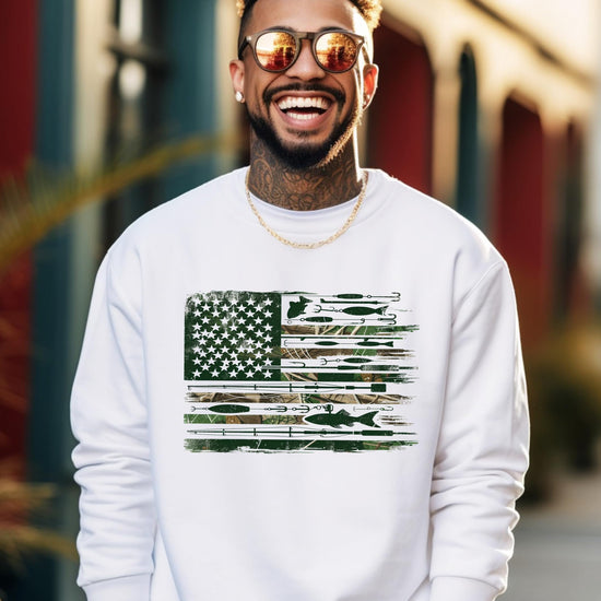 Close-up of fishing flag graphic on white sweatshirt featuring lures, hooks, and fishing rods forming an American flag