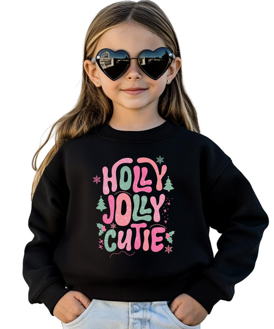 Kids black crewneck sweatshirt with pink and green Holly Jolly Cutie bubble letter Christmas graphic