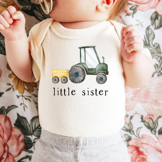 Close-up of little sister tractor print on soft natural newborn bodysuit by Olive Loves Apple