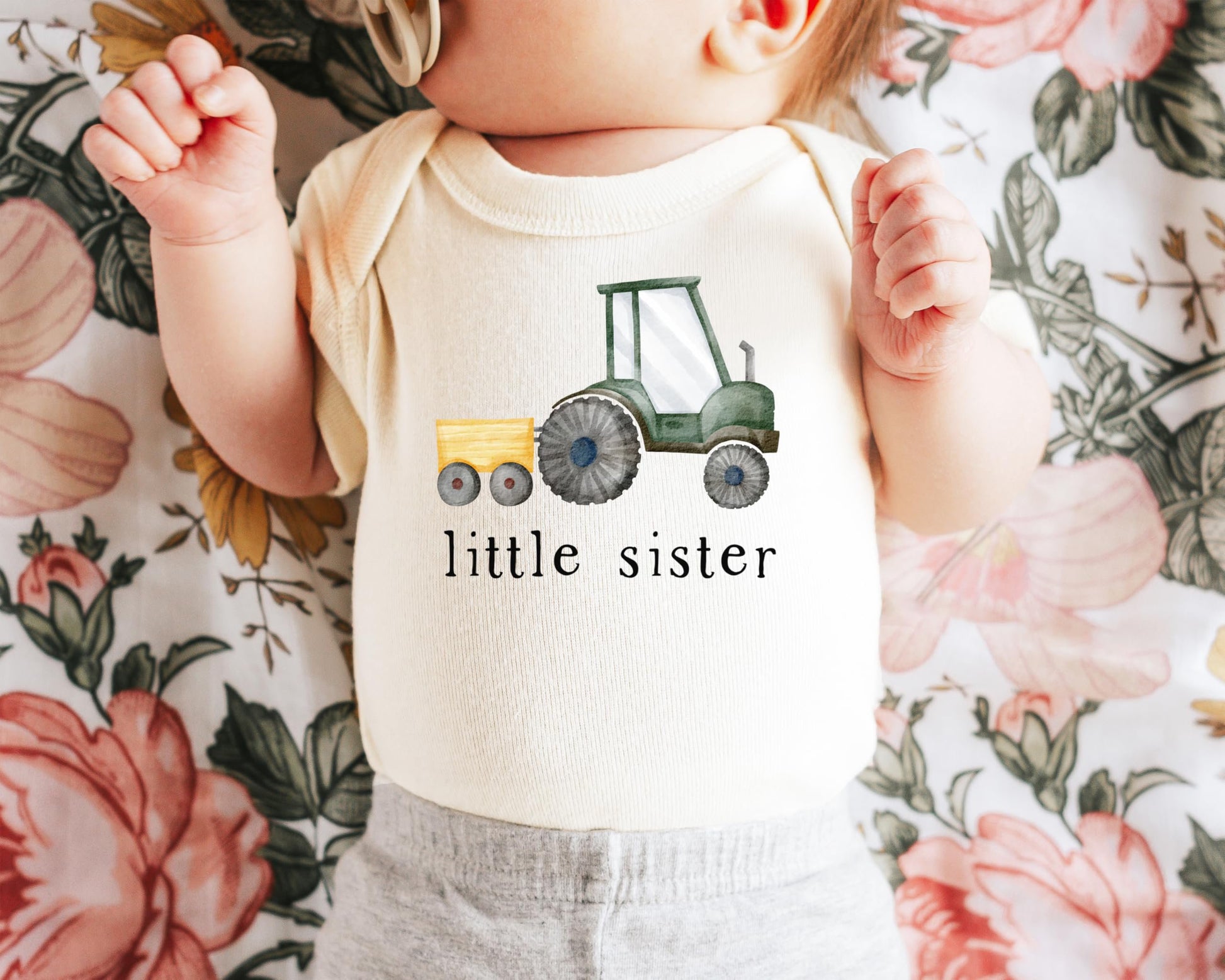 Close-up of little sister tractor print on soft natural newborn bodysuit by Olive Loves Apple