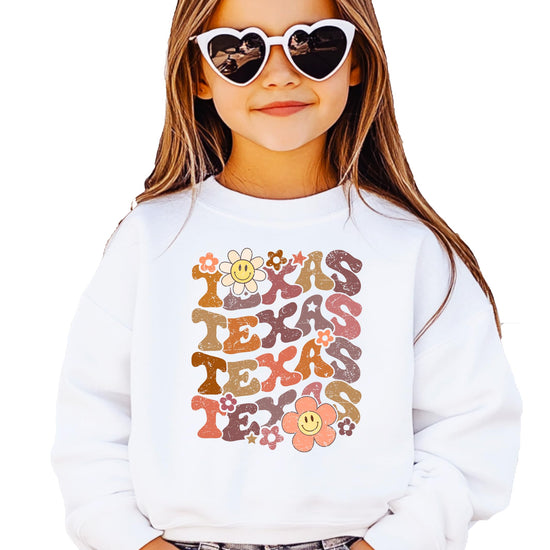 Close-up of retro groovy Texas text with smiley face flowers on sweatshirt