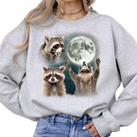 Front view of gray raccoon graphic sweatshirt showing multiple raccoon poses including moon howl
