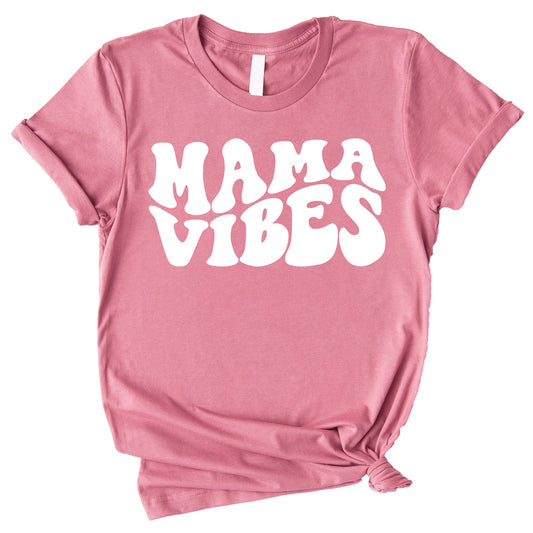Close-up of retro wavy Mama Vibes graphic print on a peach women's tee shirt