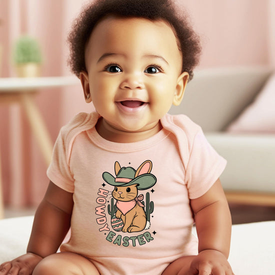 Close-up of howdy cowboy rabbit graphic print on peach infant bodysuit