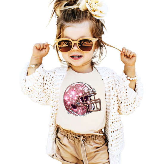 Front view of pink glitter football helmet shirt for girls on natural tee