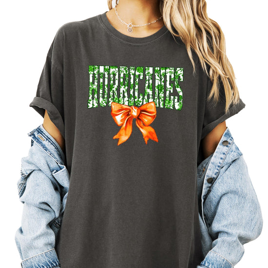 Front view of Hurricanes green floral print tee with orange bow detail on ivory shirt for women and teens