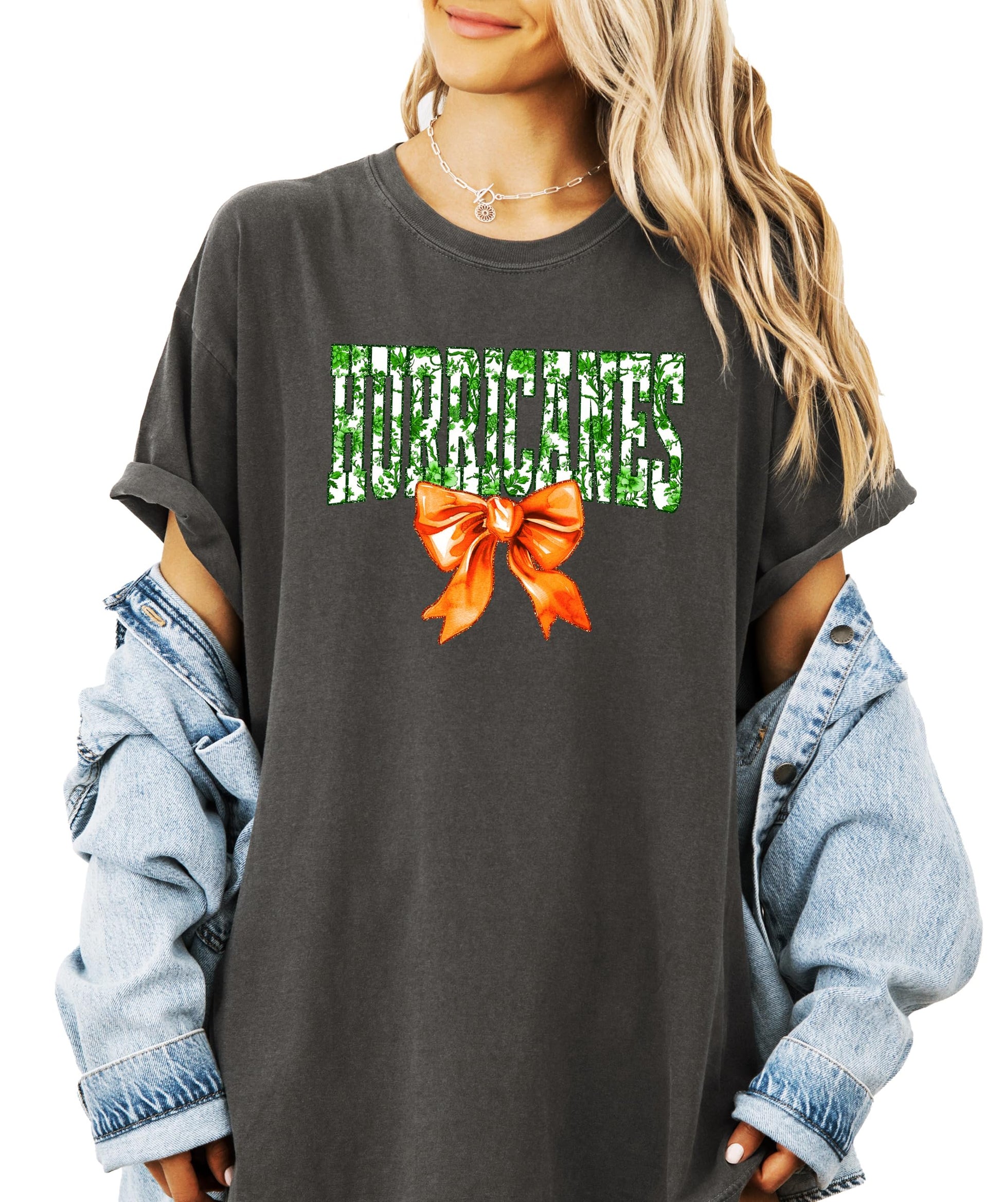Front view of Hurricanes green floral print tee with orange bow detail on ivory shirt for women and teens