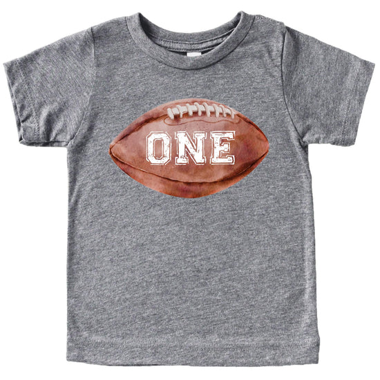 Flat lay of natural colored first birthday sports tee with distressed football print