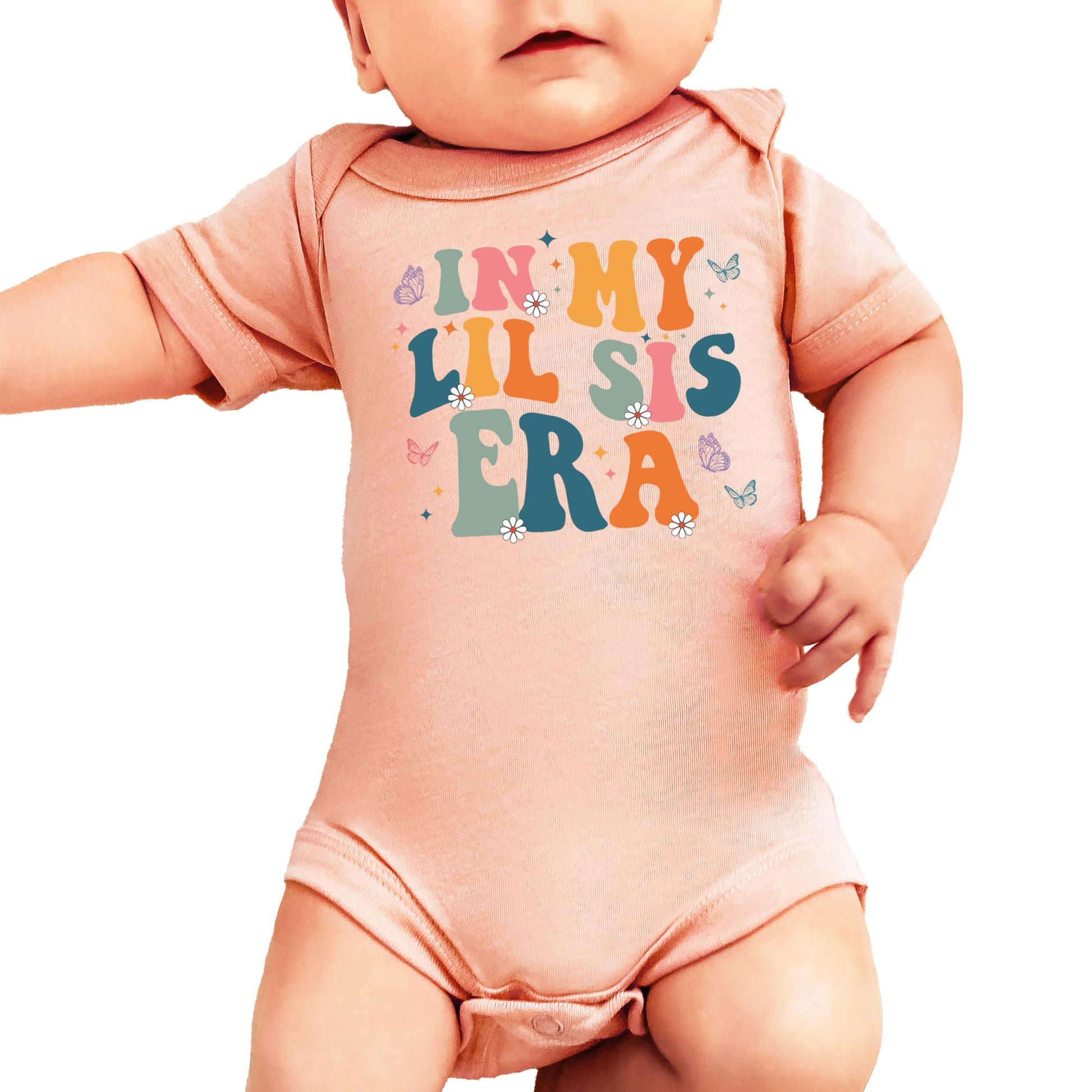 Front view of baby girl one-piece bodysuit with lil sis era graphic in soft peach and floral print