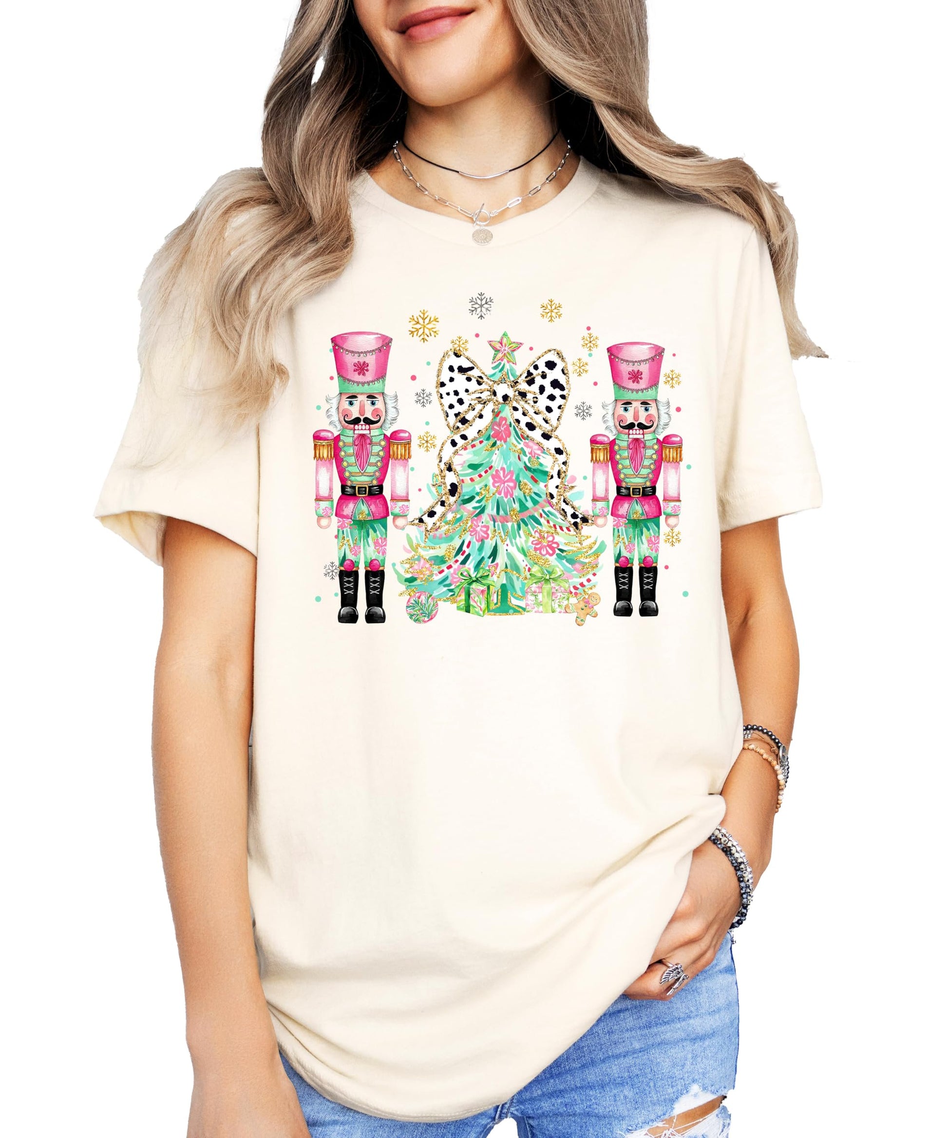 Flat lay of peach women's Christmas shirt with nutcracker and tree design by Olive Loves Apple