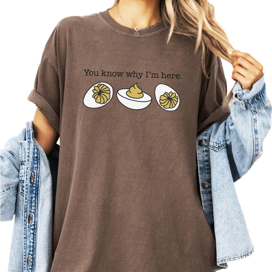 Close-up of deviled egg illustration with funny saying on brown t-shirt