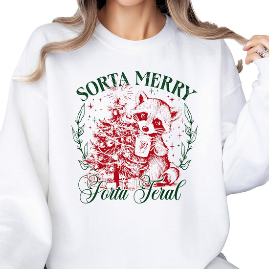 Close-up of Sorta Merry Sorta Feral raccoon Christmas tree graphic print on white sweatshirt