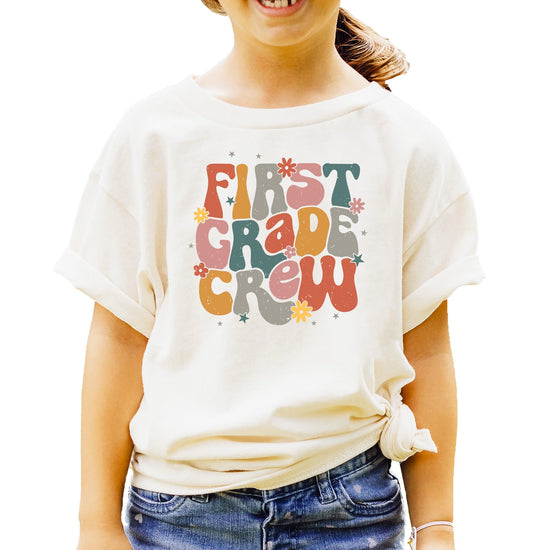 Detail shot of vibrant multicolor First Grade Crew lettering on black shirt