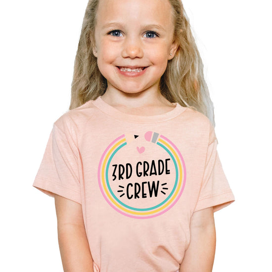 Detail shot of soft mauve fabric and colorful pencil graphic on kids back to school crew tee