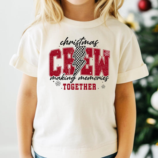 Close-up of Christmas Crew 2024 checkered holiday graphic print on soft natural t-shirt
