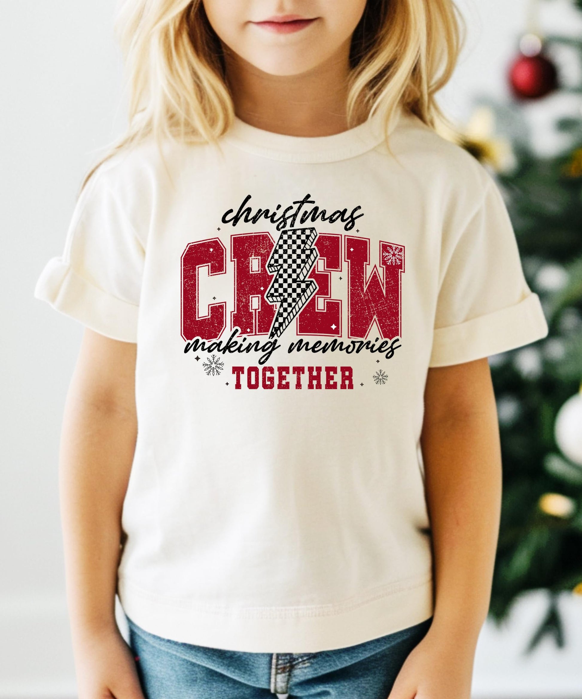 Close-up of Christmas Crew 2024 checkered holiday graphic print on soft natural t-shirt