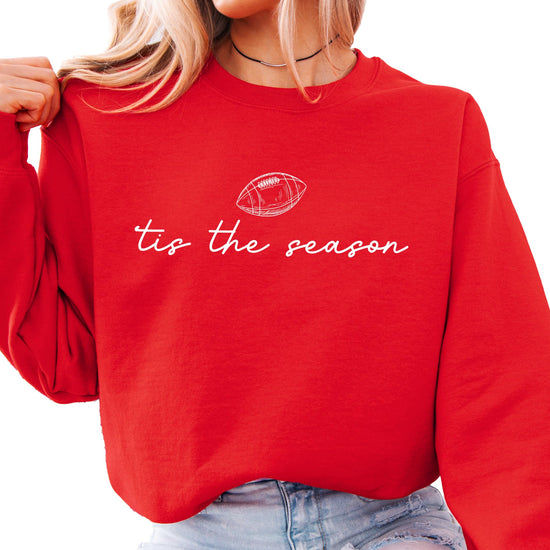 Flat lay of Olive Loves Apple 'Tis the Season football sweatshirt showing full print detail