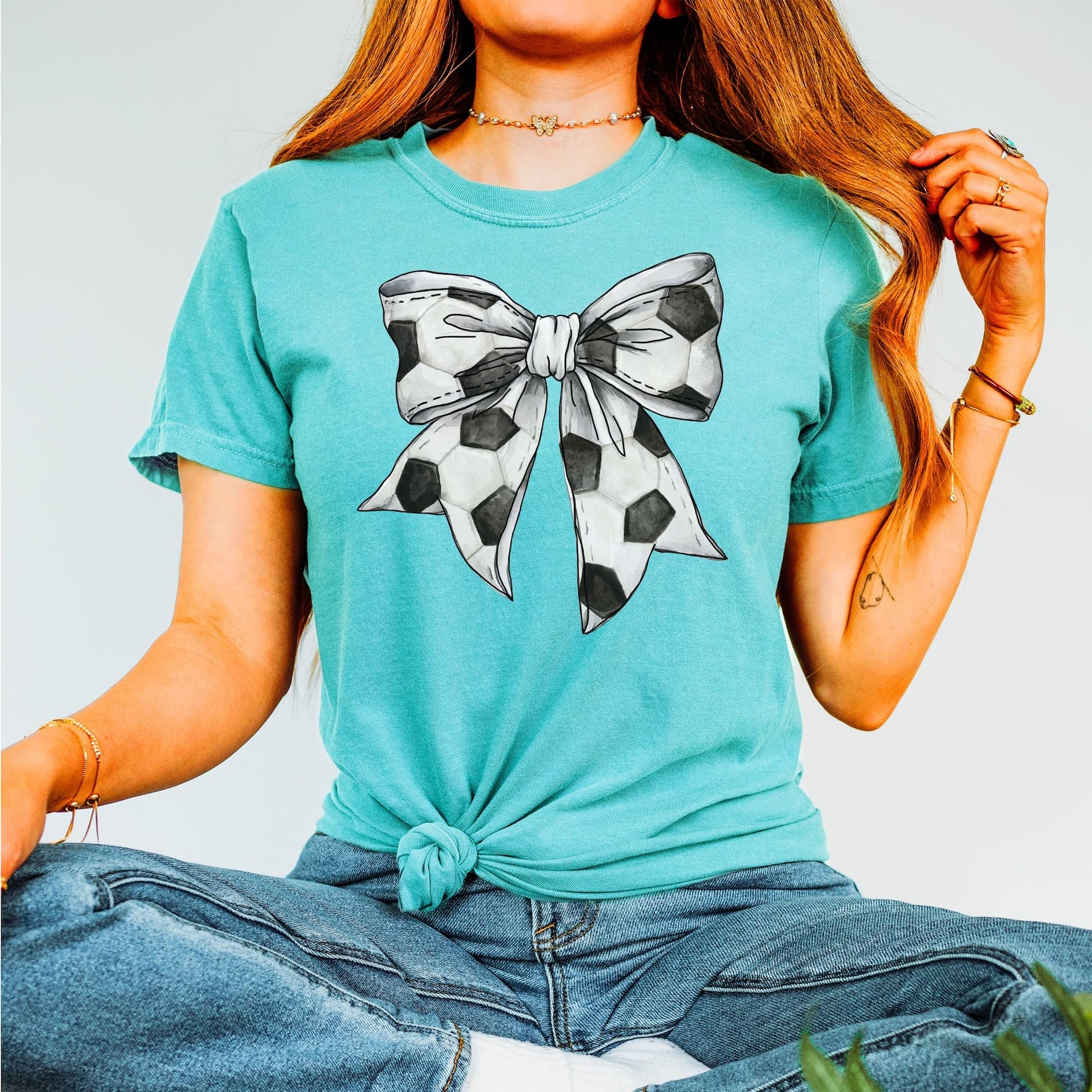 Side view of women's oversized soccer graphic tee in seafoam green