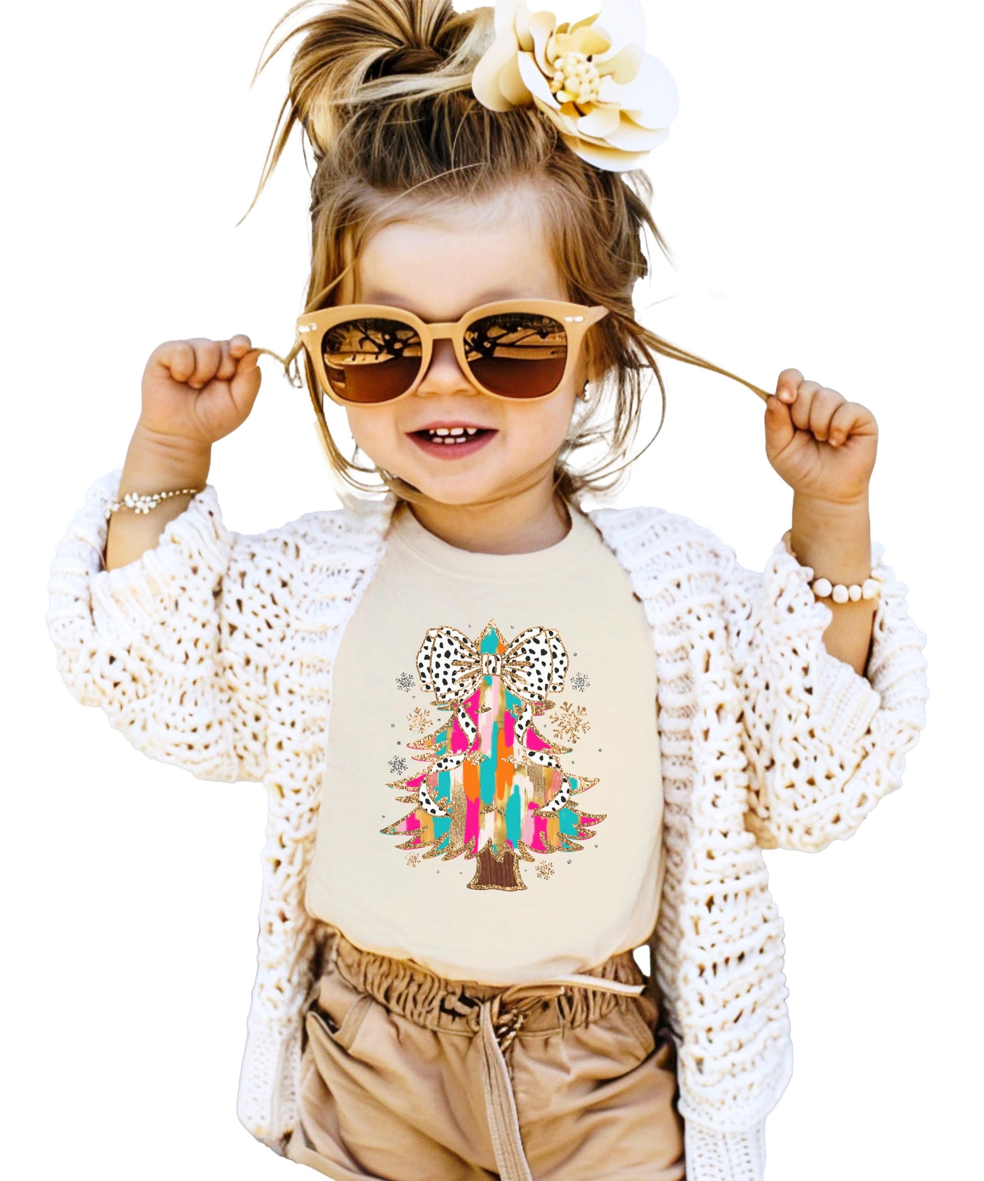 Flat lay of pink women's Christmas tee featuring Dalmatian bow-topped glitter tree graphic