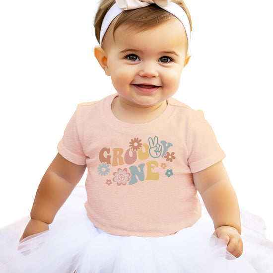 Close-up of groovy daisy One graphic print on infant birthday tee