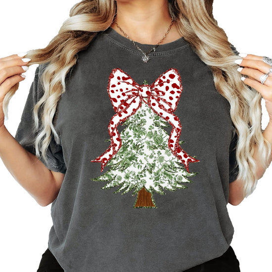 Front view of women's Christmas graphic tee featuring a faux glitter floral tree with red dot bow on top