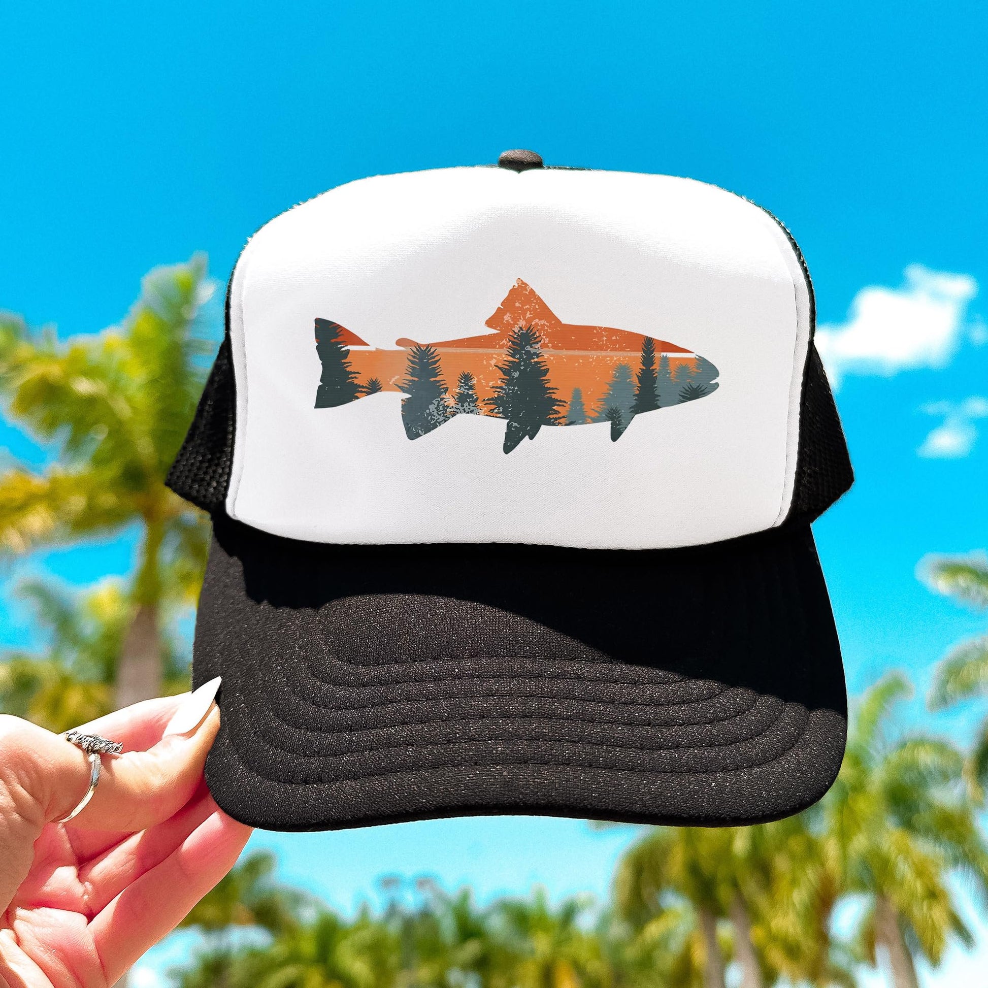 Trout fishing sunset trucker hat held against blue sky - white and black snapback