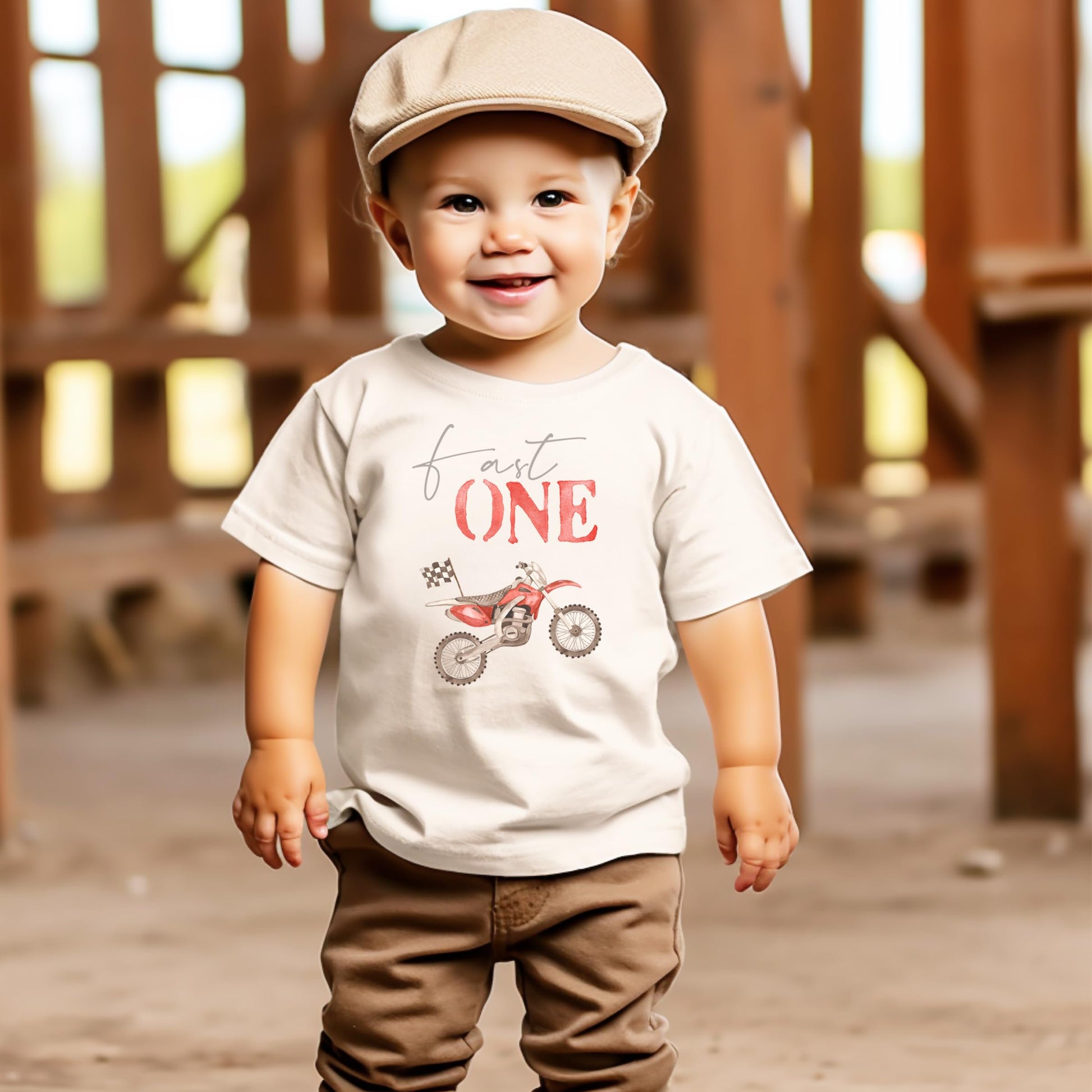 Close-up of red dirt bike and checkered flag graphic on boys first birthday tee