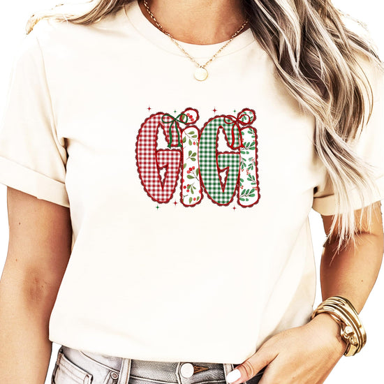 Close-up of faux lace ink-printed holiday design with holly and red bow details on Christmas tee