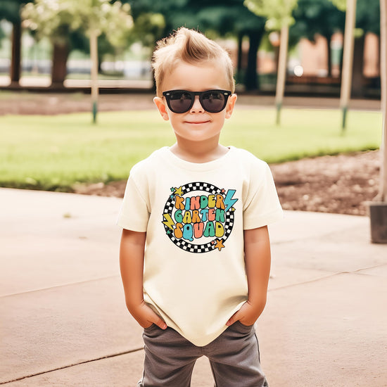 Kindergarten squad first day of school graphic tee flat lay on military green t-shirt