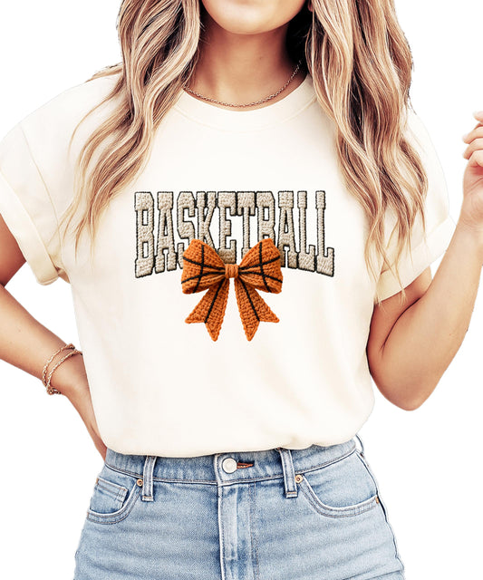 Women's ivory graphic tee with coquette basketball bow design and Basketball text, ink-printed patch style