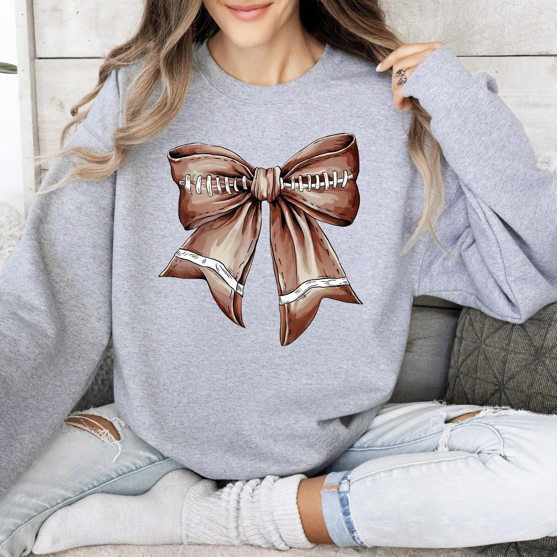 Flat lay of white Football Coquette Bow Sweatshirt trendy game day pullover for women