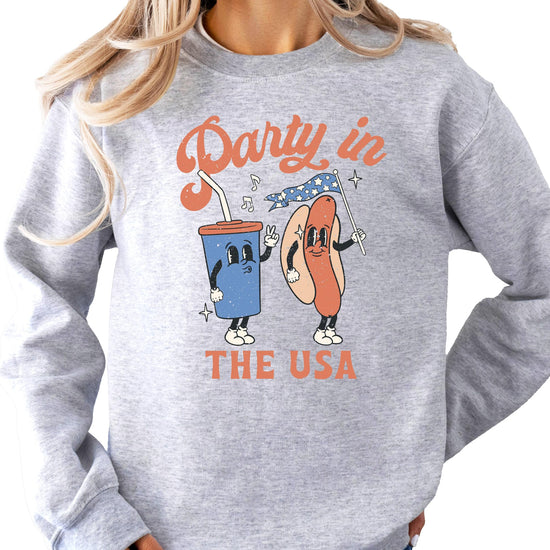 Women wearing Party In The USA white graphic sweatshirt for Fourth of July celebration