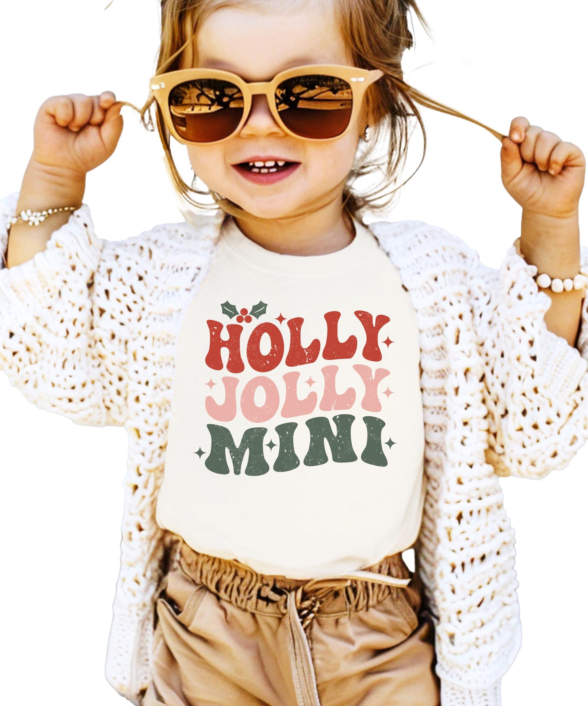 Close-up of Holly Jolly Mistletoe graphic print on natural matching Christmas tee