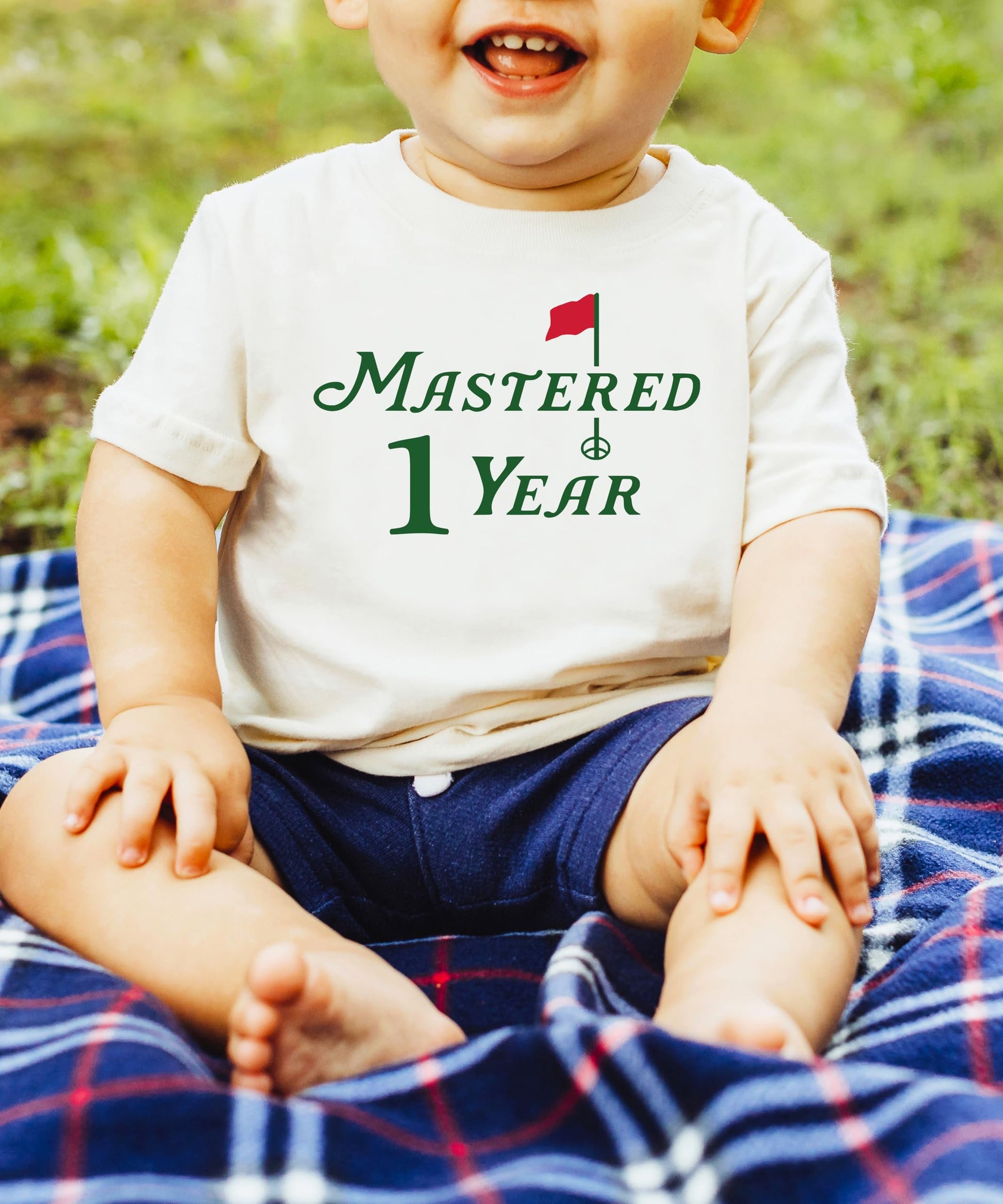 Toddler wearing Mastered 1 Year golf first birthday tee in natural color
