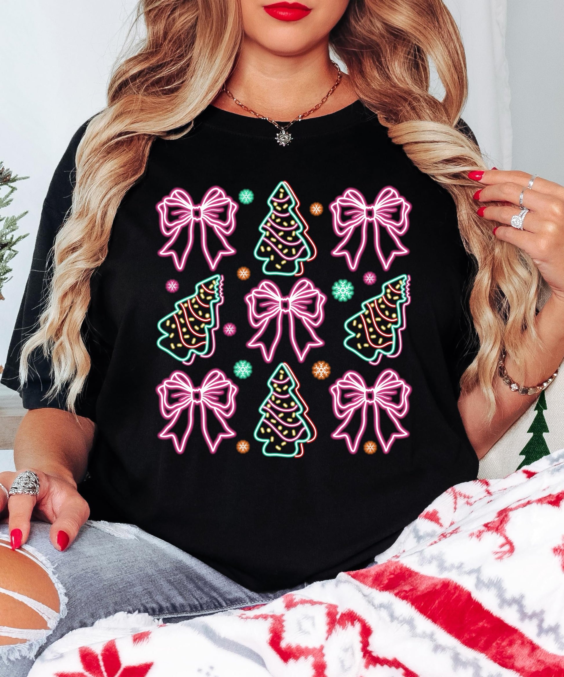 Side or lifestyle view of women's black festive Christmas graphic tee with neon gift bows and trees