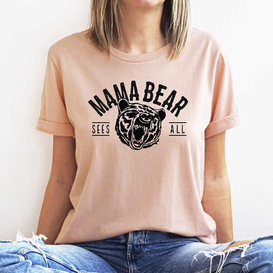 Back or side detail view of Mama Bear Sees All peach graphic shirt