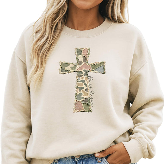 Close-up of ink-printed He Is Risen cross graphic on camo women's pullover sweatshirt