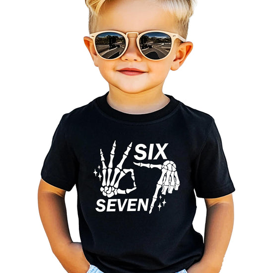Black t-shirt with white skeleton hand showing six seven finger gesture Halloween meme design