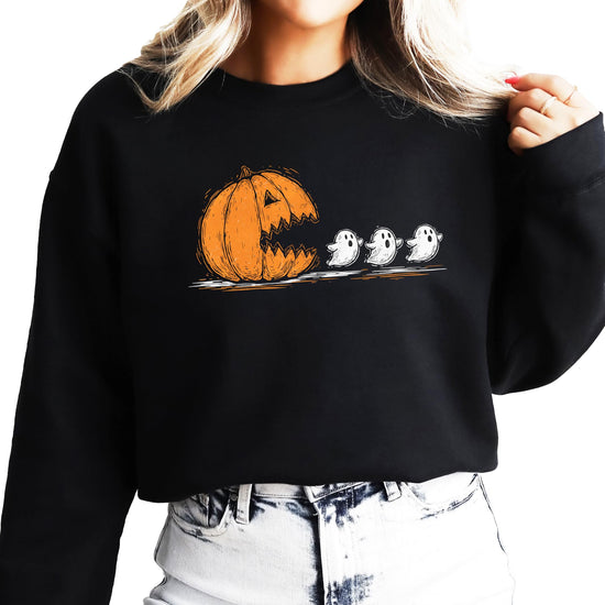 Teen wearing a cute pumpkin ghost Halloween sweatshirt in a fall outdoor setting