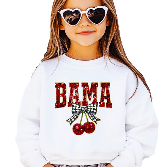 Close-up of red ink-printed sequin BAMA graphic with checkered bow and disco cherry accents on white sweatshirt