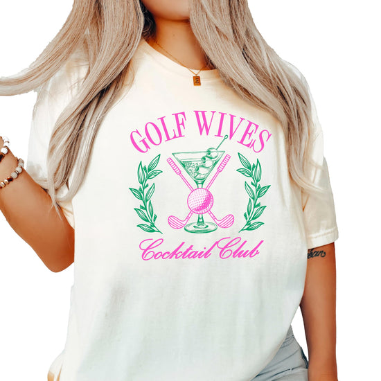 Front view of Golf Wives Cocktail Club women's graphic tee in ivory with bold cocktail and golf club design