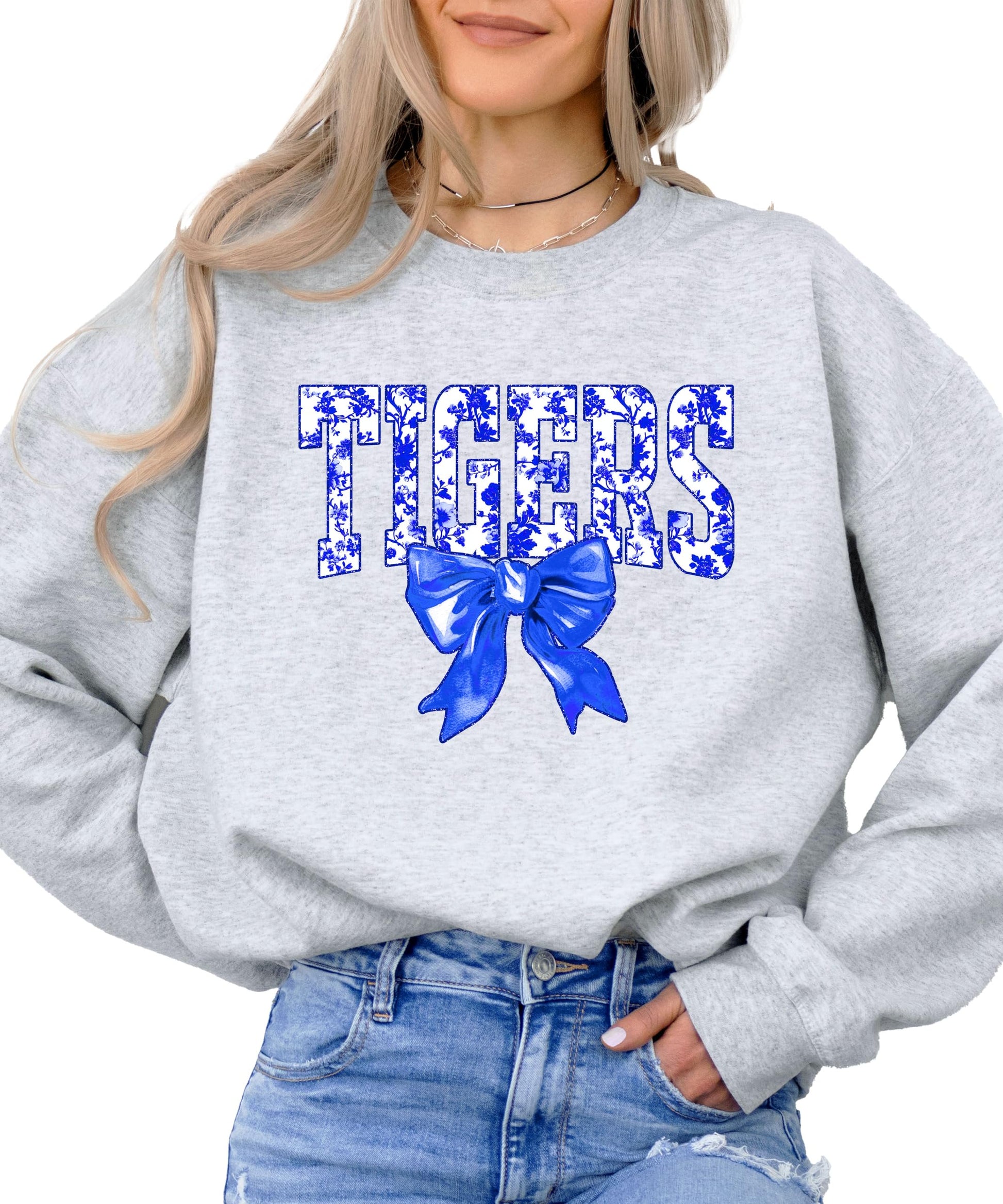 Tigers sweatshirt front view showing blue floral lettering and bow detail on white pullover