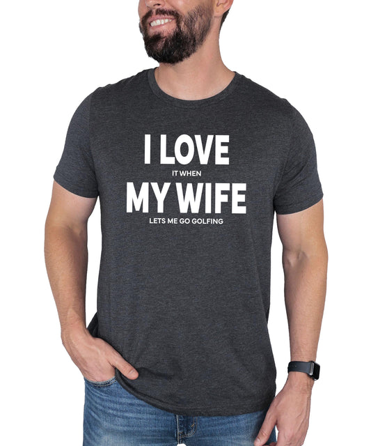 Dark gray heather men's tee with bold text reading I Love It When My Wife Lets Me Go Golfing