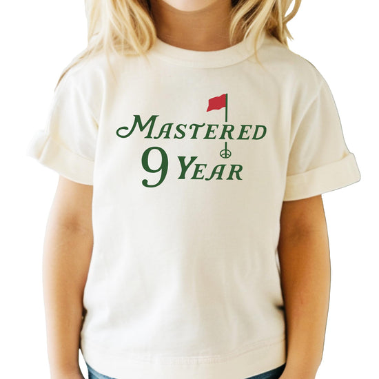 Front view of golf-themed birthday shirt for boys and girls in natural color