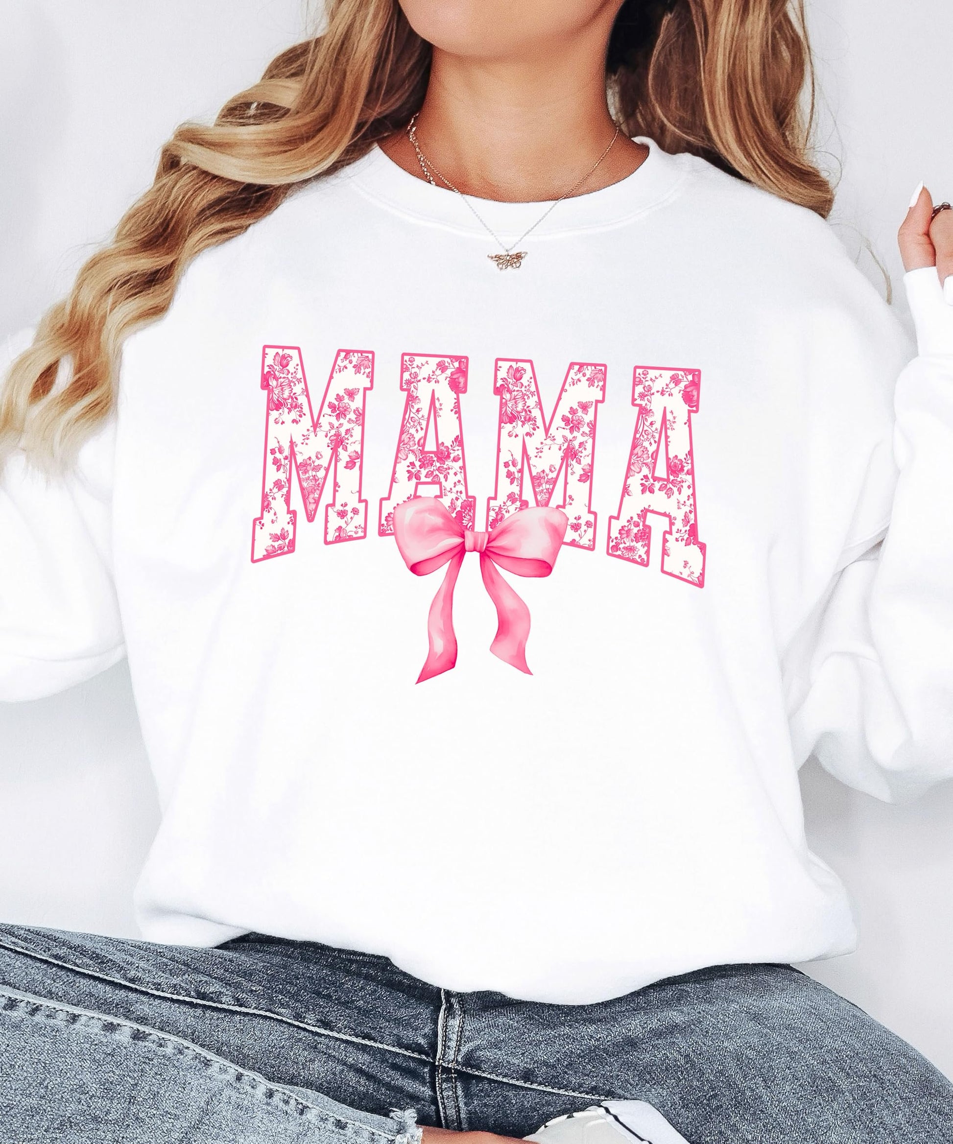 Flat lay of black MAMA sweatshirt with pink bow graphic detail