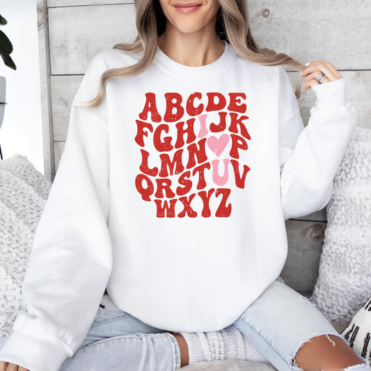 Front view of Valentine's Day alphabet heart graphic sweatshirt by Olive Loves Apple